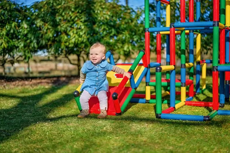 Toddler seated on a red ramp beside the base of a QUADRO tower