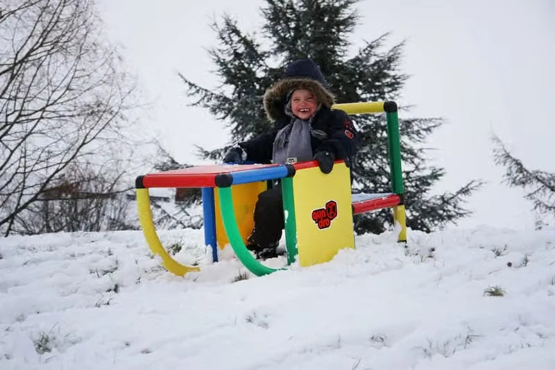 Child leaning over a low QUADRO curved tube frame in the snow