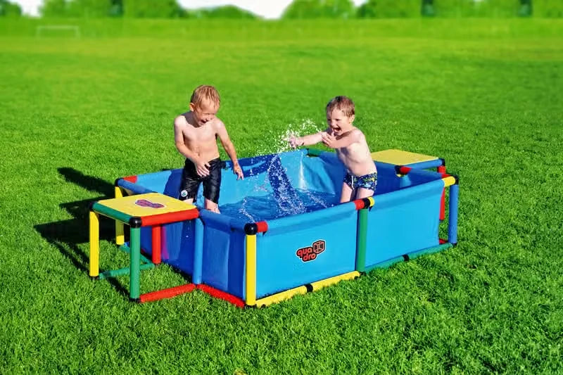Two children splashing in a large rectangular blue QUADRO pool
