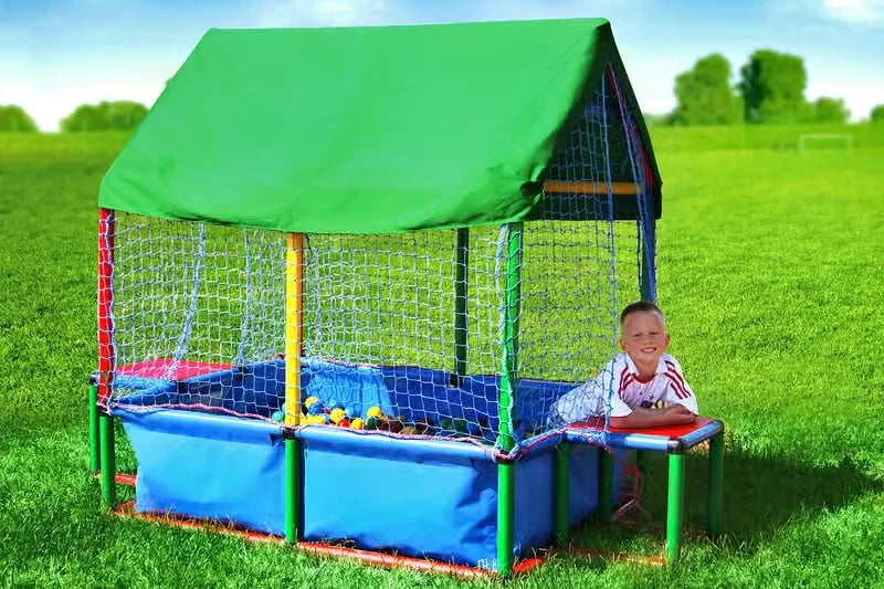 Child beside a roofed and netted QUADRO pool configured as a ball cage